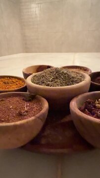 Arabian luxury chic. Expensive organic spices, scrubs, and natural powders in wooden bowls for a traditional hammam ritual. Elite high-end spa wellness treatments and rich lifestyle concept.