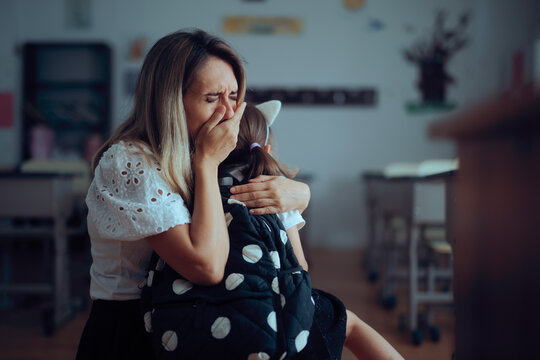 Emotional Mother Crying and Hugging Daughter on First School Day. Mom hugs young girl during sentimental back to school return