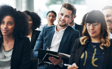 Obraz premium Man, listening or audience writing in seminar for business speech, finance expo or budget info. Crowd, happy person or notes at global convention for wealth management, learning or career development
