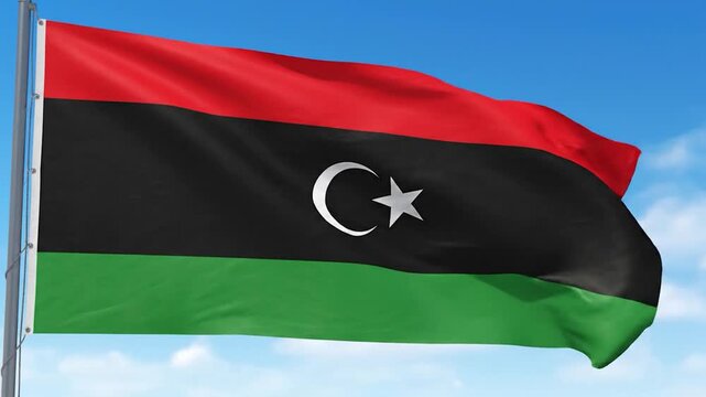 The national flag of Libya proudly waves against a clear blue sky, symbolizing