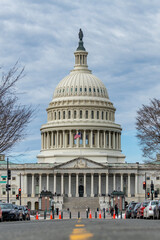 Obraz premium Capitol in united states skyline. Federal Capitol on blue sky in Washington DC. Patriotic Capitol with American flag in daytime. Iconic Capitol architecture on cloudy background.
