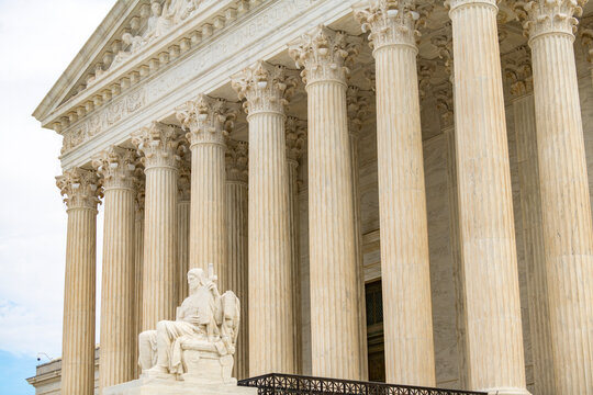 Authority of Law statue at supreme court facade. Law constitution lex judicial power. Justice statue allegory with marble columns. Historic courthouse landmark architecture.