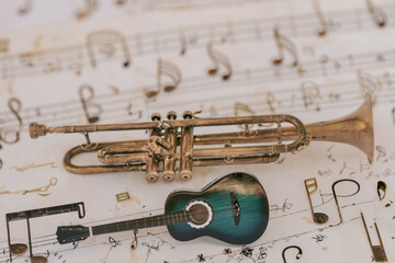 Obraz premium a guitar and an old jazz trumpet on a plane of jumbled musical notes