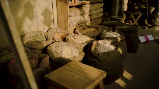 Open burlap sacks filled with grains in bazar shop