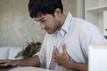 Fototapeta premium hand hold chest with heart attack symptoms, asian man have chest pain caused by heart disease, leak, dilatation, enlarged coronary heart, press on the chest with a painful expression