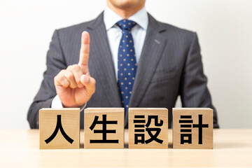 Obraz premium 「人生設計」と書かれたブロックとビジネスマン
