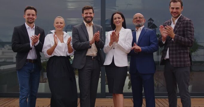 Corporate employees give applause on rooftop celebration, showing team recognition, group applauding to success goal achievement, unity and partnership outdoors. Business people clap hands on rooftop