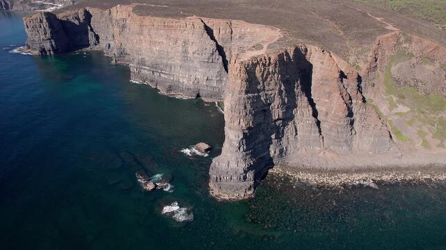 Massive sedimentary sandstone fal&eacute;sias shaped by marine erosion rising vertically above Atlantic Ocean near Vila Nova de Mil Fontes Odemira Alentejo Portugal with visible stratification