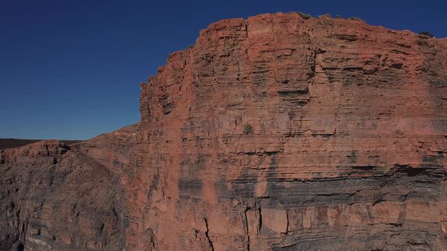 Stratified sandstone fal&eacute;sia cliff face at Vila Nova de Mil Fontes Odemira Alentejo Portugal showing horizontal sediment layer, vertical fracture and marine erosion texture above Atlantic Ocean, orbit