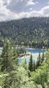 Caumasee Lake Cauma turquoise color water alpine highlands nature, aerial drone vertical video Switzerland