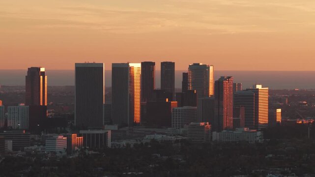 Telephoto panning aerial shot of Century City during golden hour in Los Angeles, California. 4K