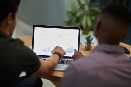 Men, laptop and analytics with chart for business statistics, performance review or analysis. Male people, employees or analyst with computer display, screen or graph for company data or progress