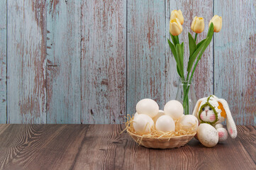 Fototapeta premium Easter bunny with white eggs and tulips in vase
