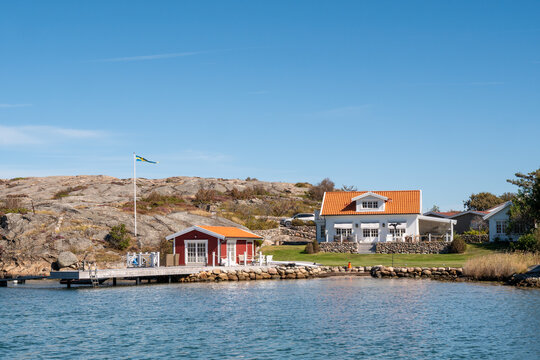 Coastal houses at Gr&ouml;nvik along Sotekanalen, Sote Canal, Bohusl&auml;n, west coast Sweden, with jetty, rocky shoreline and calm sheltered water