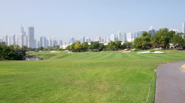 Lush green golf course with Dubai skyline in the background, showcasing modern architecture and vibrant landscaping
