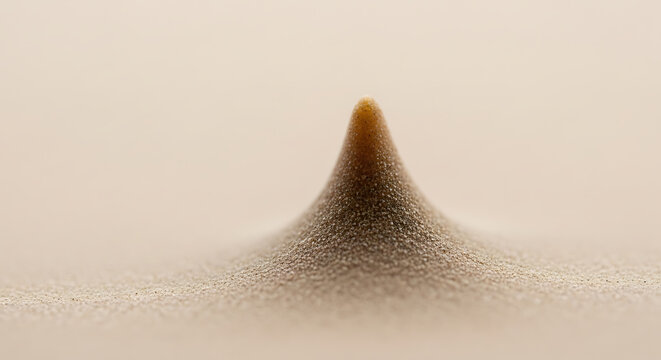A mound of sand rises in the desert landscape with a solitary peak.