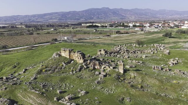 Cinematic aerial drone video of Tripolis Antik Kenti near Buldan in Denizli, Turkey, featuring Roman ruins, columns, stone structures, and panoramic scenic landscape from above.