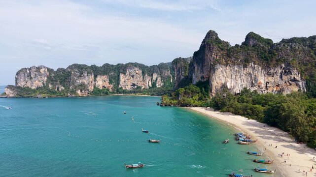 Stunning aerial footage of Railay Beach in Krabi, Thailand, showcasing turquoise waters, sandy shores, and dramatic limestone cliffs. Perfect for travel and nature enthusiasts.