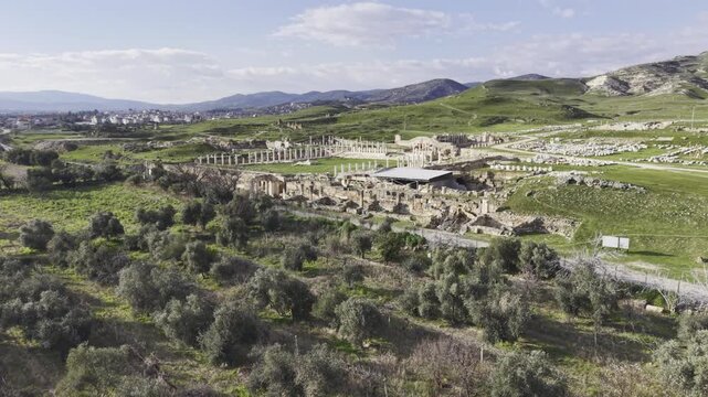 Cinematic aerial drone video of Tripolis Antik Kenti near Buldan in Denizli, Turkey, featuring Roman ruins, columns, stone structures, and panoramic scenic landscape from above.