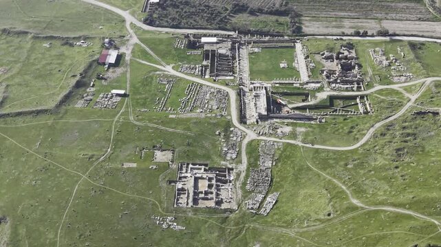Cinematic aerial drone video of Tripolis Antik Kenti near Buldan in Denizli, Turkey, featuring Roman ruins, columns, stone structures, and panoramic scenic landscape from above.