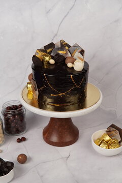 Elegant Coco Gold Tall Cake featuring multiple layers of rich chocolate sponge with creamy frosting and luxurious decoration. This tall celebration cake stands out with its premium presentation and in