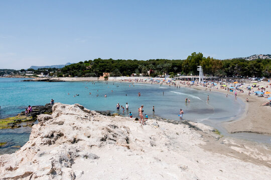 People enjoying sunny Mediterranean beach and clear sea