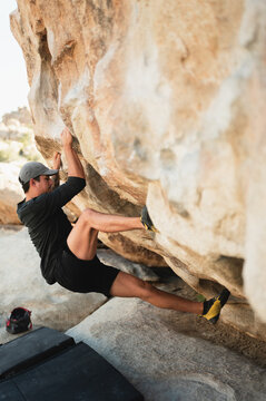 Climber placing foothold while bouldering in Joshua Tree desert