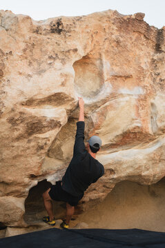 Back view of climber bouldering on rock in Joshua Tree desert