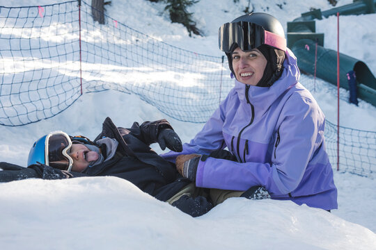 Mom and sun take a break from snowboard and play in snow