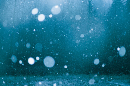 Snowflakes fall against dark background in storm