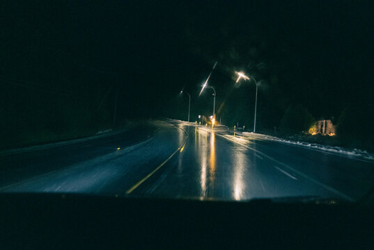 POV driving down highway at night with blur from rain and motion