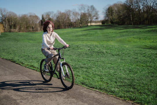 Teenage girl riding a bicycle in the park, spring time