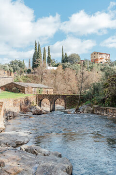 Historic stone arch bridge over mountain river in rural village
