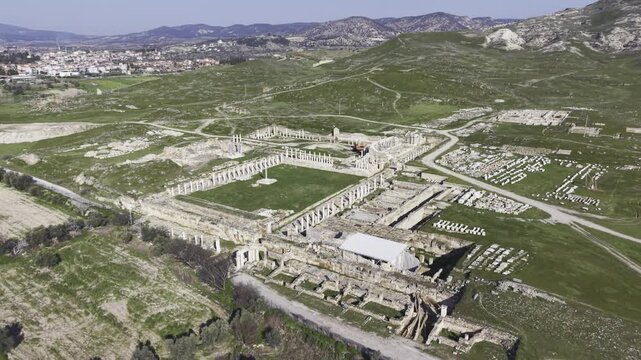 Cinematic aerial drone video of Tripolis Antik Kenti near Buldan in Denizli, Turkey, featuring Roman ruins, columns, stone structures, and panoramic scenic landscape from above.