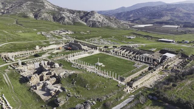 Cinematic aerial drone video of Tripolis Antik Kenti near Buldan in Denizli, Turkey, featuring Roman ruins, columns, stone structures, and panoramic scenic landscape from above.