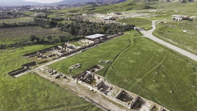 Cinematic aerial drone video of Tripolis Antik Kenti near Buldan in Denizli, Turkey, featuring Roman ruins, columns, stone structures, and panoramic scenic landscape from above.