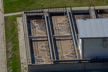Fototapeta premium Water purification facilities with filtration tanks and treatment systems located outdoors under clear skies during daylight