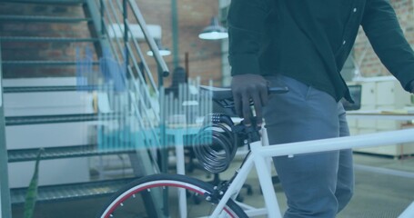 Standing man in green shirt gray pants holding white bicycle at loft office staircase, copy space © vectorfusionart