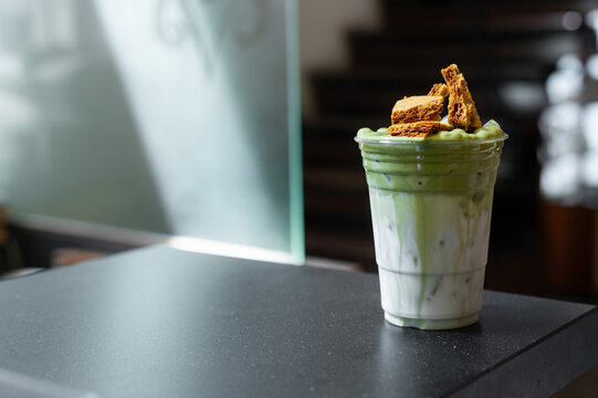 Iced matcha latte layered with milk and topped with crunchy brown sugar waffle pieces