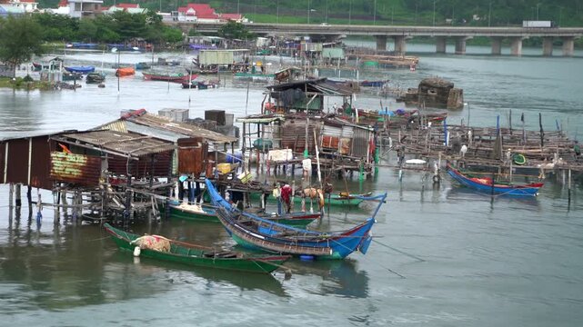 Stilt houses and fishing boats in a small natural harbor in Vietnam near Hoi An, traditional life in poverty in Asia Vietnam