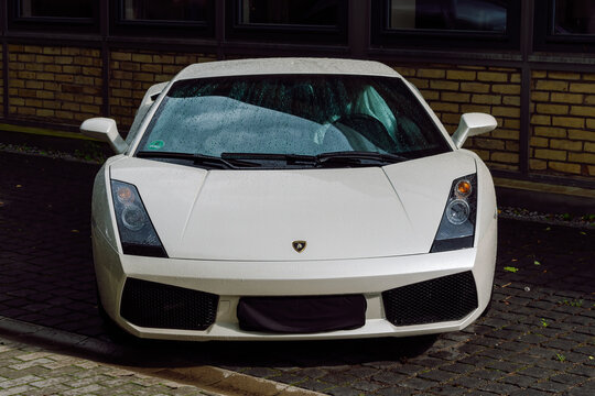 Front View of a Luxury White Lamborghini Gallardo Parked on a Wet Cobblestone Street in Berlin, Germany