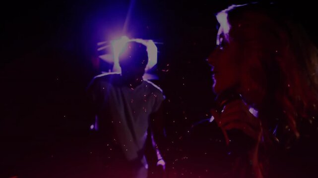 Lead singer holding mic onstage while cam moving closer, singing, dust glowing, backup raising arm