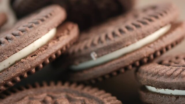 A close up view of a stack of chocolate cream cookies, slowly rotating, offering a sweet and tempting visual, ideal for food advertisements and dessert-related content