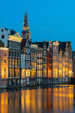 Dancing houses near tower of Oude Kerk Amsterdam Church at twilight, Damrak, Amsterdam, Netherlands