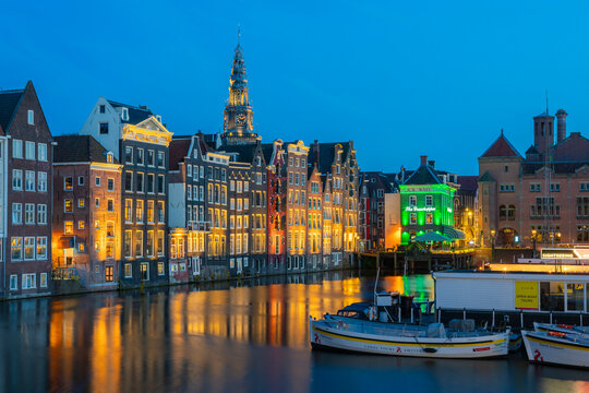 Dancing houses near tower of Oude Kerk Amsterdam Church at twilight, Damrak, Amsterdam, Netherlands