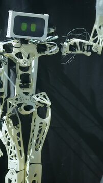 Robot with a white head and black body. The robot has a white hand and a black foot