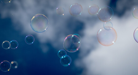 Iridescent, rainbow colored soap bubbles floating through the air