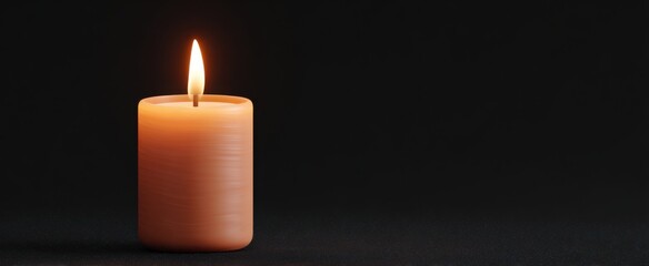 A lit candle emits a warm glow on a dark surface.