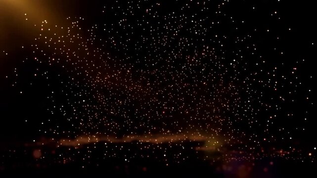 Golden particles explode and shimmer against a dark background with light rays.