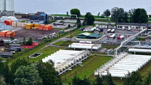Aerial view of an industrial warehouse with silos and above ground gas storage.